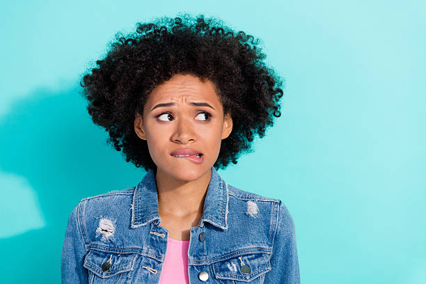istock Photo of pretty scared young lady dressed denim jacket biting lip looking empty space isolated teal color background 2211624375