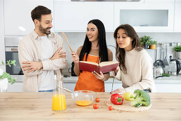 istock Group Cooking Fun with Cookbook and Smiles 2211625433