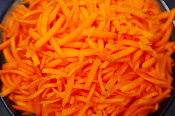 a large bowl of grated carrots. Cooking a vegetable salad from fresh vegetables. all-purpose grater.