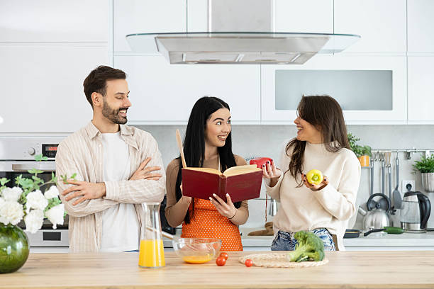 istock Engaged Cooking Friends with Cookbook Open 2211625452