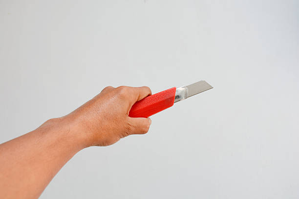 Hand holding a red cutting knife