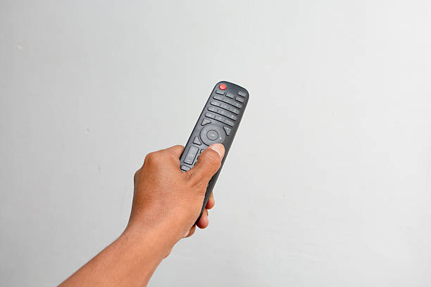 Hand holding remote control of television