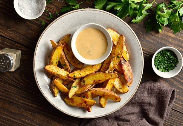 istock Baked potato wedges served with dip sauce 2211628764