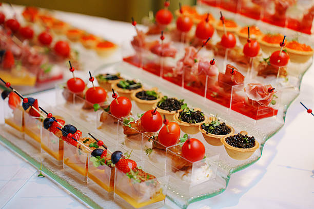 different canapes in cups with sauce and tartlets with black caviar. Convenient and beautiful serving of appetizers at a buffet table. catering at events.