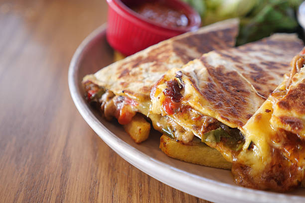 A mouthwatering quesadilla with fresh salsa, served beautifully on a wooden table