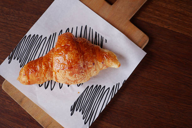 istock fresh baked croissant on plate with copy space 2211633523