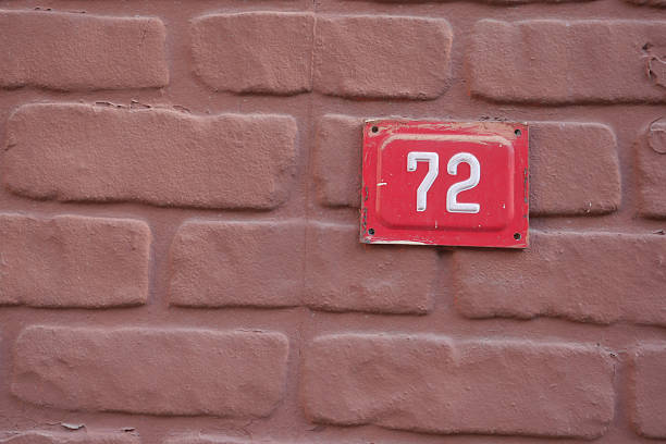 istock The number 72 stands out on a Red Tile against a Brown Brick Wall 2211633751