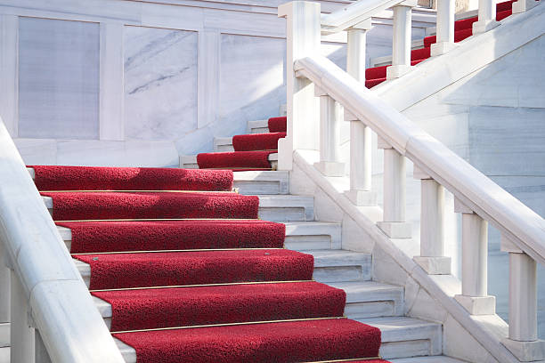 istock An Elegant Red Carpeted Staircase featuring Beautiful White Marble accents 2211634454