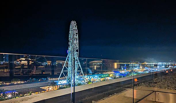 A vibrant Ferris wheel glows brilliantly against the night sky in Manila, Philippines, captured from a high angle on January 15, 2025. The dazzling lights radiate festivity and energy, reflecting the lively spirit of the city's nightlife. This striking night-time urban scene is perfect for themes of travel, cultural vibrancy, city attractions, and entertainment photography.