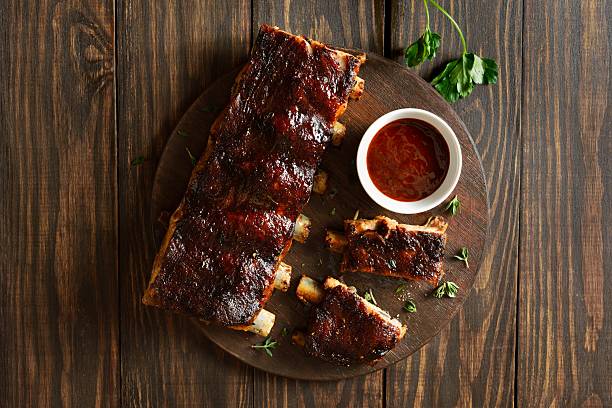 istock Bbq pork ribs served with sauce, top view 2211640343