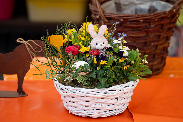 istock A basket of flowers with a rabbit in it sits on a table 2211640661