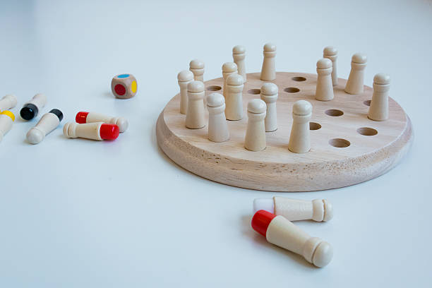 istock Wooden strategy game board with colorful pegs and dice on white surface 2211642109