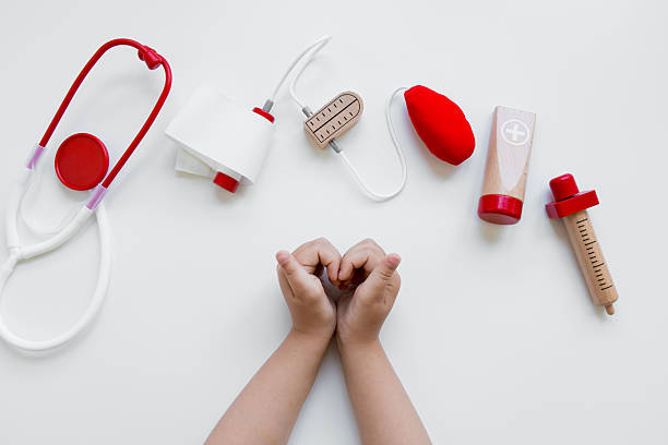 istock Child hands with toy medical tools on white background 2211643050