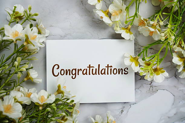istock Congratulations text message on paper card with flower decoration on marble background 2211650059