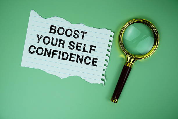 istock Boost Your Self Confidence text written on paper with magnifying glass flat lay on green background 2211650083