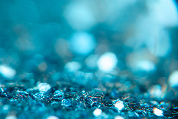 Shimmering blue glitter covers the surface, reflecting light and creating a dazzling effect.