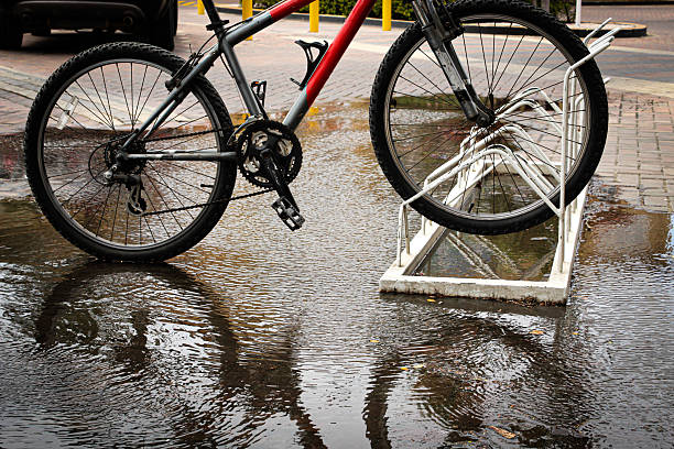 istock a bicycle leaning against a bike rack on a wet surface, with a reflection visible in the water after the rain 2211651430