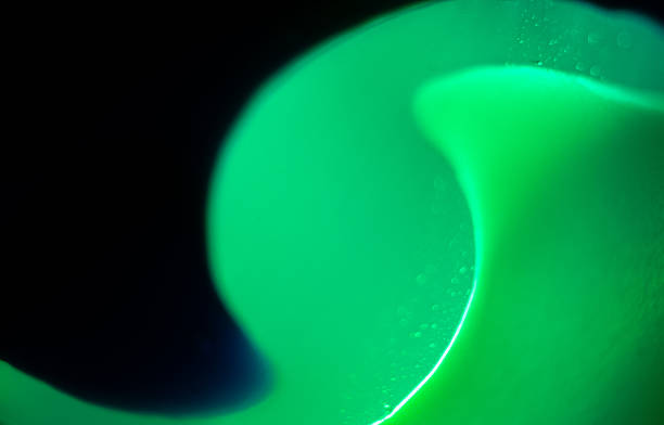 istock Bright green liquid swirling in dark background creates an abstract visual effect 2211652232
