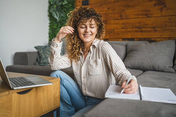 istock young adult woman use laptop and take notes in notebook remote work 2211655854