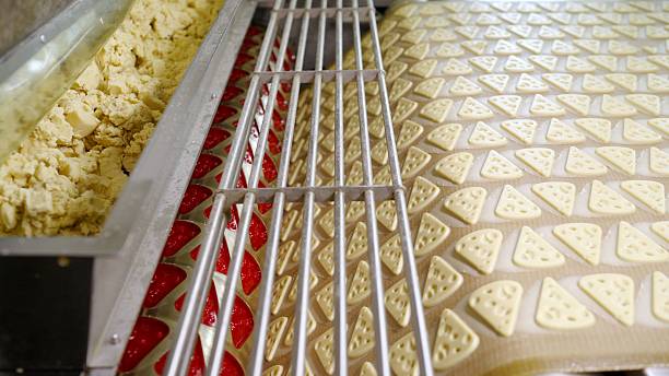 istock Cookies moving on conveyor belt in food processing plant 2211657156