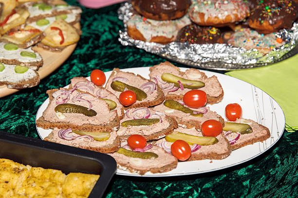 Assorted open-faced sandwiches with pickles, onions, and cherry tomatoes on dark bread, lifestyle