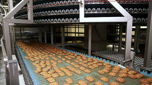istock Cookies moving on conveyor belt in food processing plant 2211658301