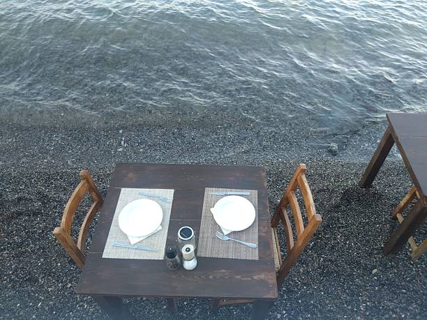 Close up taken of An empty table with four chairs by the blue sea