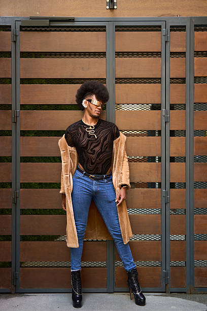 istock Young androgynous model posing in front of wooden gate 2211659048