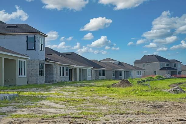 istock Construction development grounds with a row of new concrete block homes 2211661891