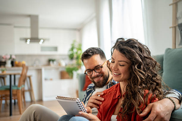 istock Young couple planning their future, taking notes at home 2211664316