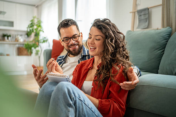istock Young couple planning and writing notes in notebook at home 2211664324