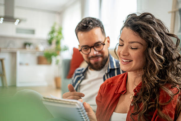 istock Young couple planning finances and smiling at home 2211664373