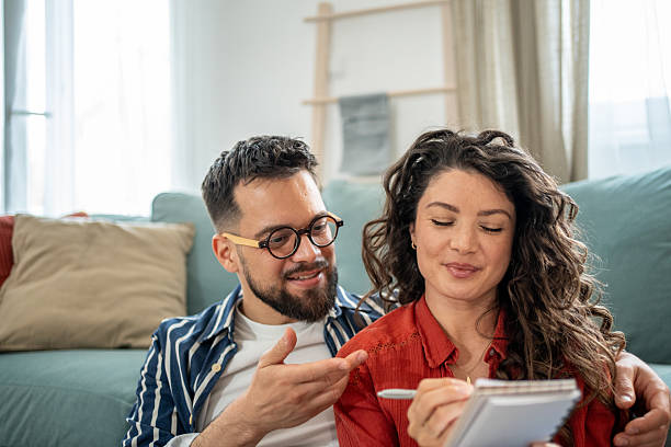 istock Young couple doing home finances together and taking notes on notepad 2211664555