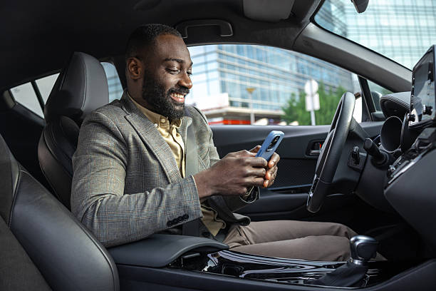 istock Businessman using smartphone in a modern car with a cheerful expression 2211667374