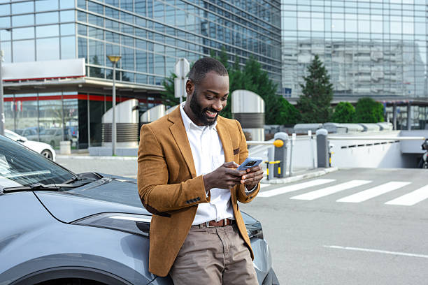 istock Man leaning on a car using smartphone in urban setting 2211667945