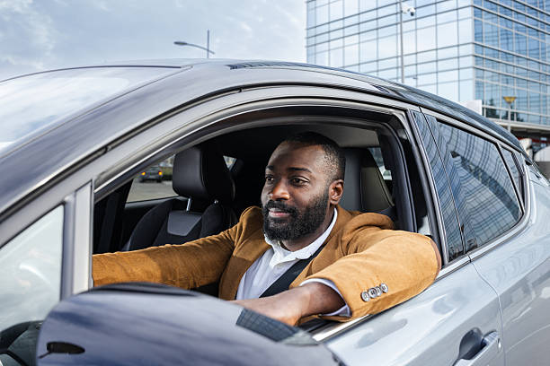 istock Smiling man enjoying driving a car in an urban environment 2211668072