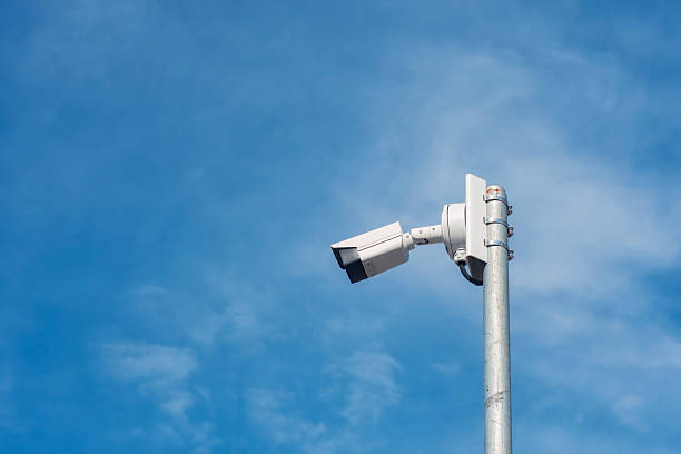 istock Outdoor CCTV camera on a metal pole against a clear blue sky. 2211671808