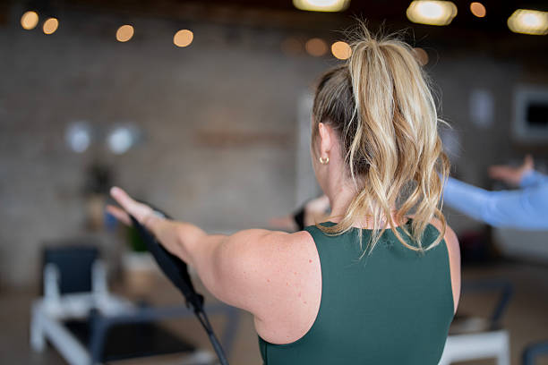 istock Focused Woman Exercising with Resistance Reformer in a Modern Studio 2211676548