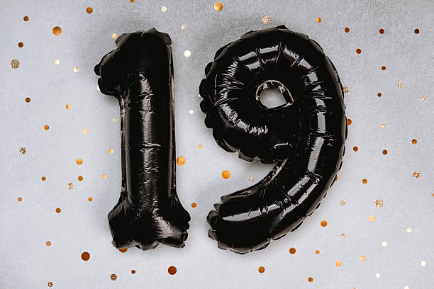 istock Black balloons shaped like the number 19 on a sparkling background 2211676777