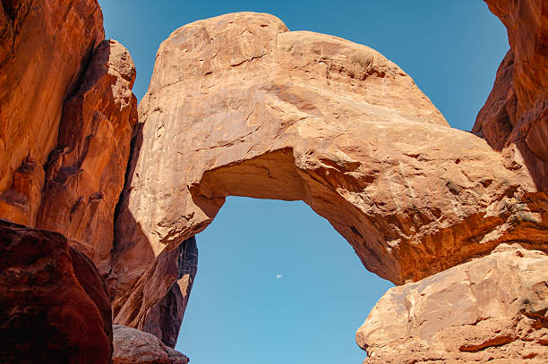 istock Moon Peeks Below A Massive Arch in Arches National Park 2211677766