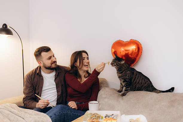 istock Couple Enjoying Sushi While Feeding Their Cat in Cozy Home Setting 2211681953