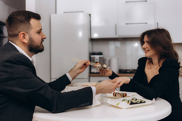 istock Elegant Couple Enjoying a Romantic Sushi Dinner in a Modern Home 2211681983