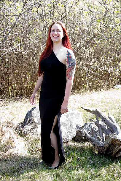 The beautiful redheaded model CJ practices with her sword on the river.