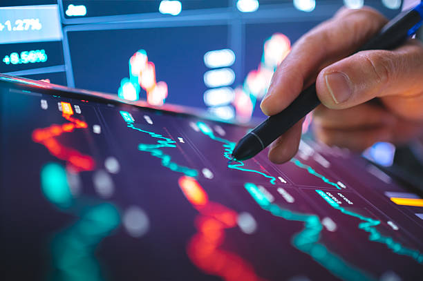 istock Investor decision-making preparing to sell stocks on tablet screen while multiple financial graphs display volatility. emphasizes emotional investing, AI-assisted trade 2211689148