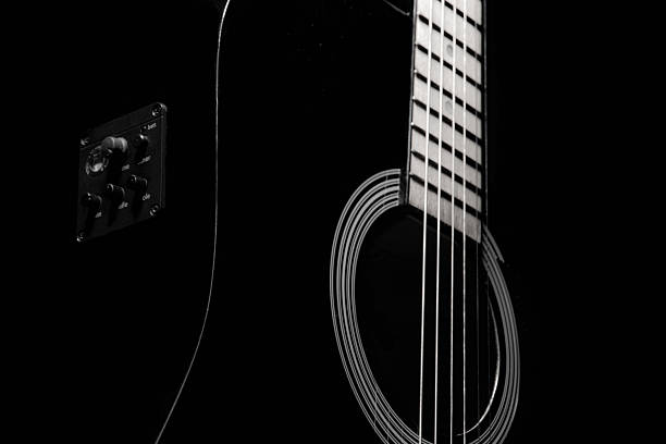 istock black acoustic guitar on a black background, silhouette. black and white, close-up, front side view 2211689182