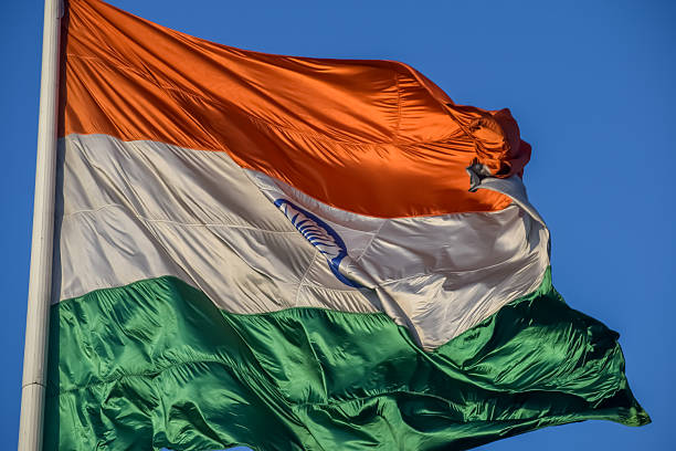 istock India flag flying high at Connaught Place with pride with plain white background, India flag fluttering, Indian Flag on Independence Day and Republic Day of India, tilt up shot, Har Ghar Tiranga 2211693564