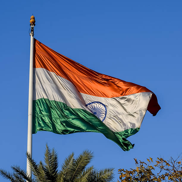 istock India flag flying high at Connaught Place with pride with plain white background, India flag fluttering, Indian Flag on Independence Day and Republic Day of India, tilt up shot, Har Ghar Tiranga 2211693575
