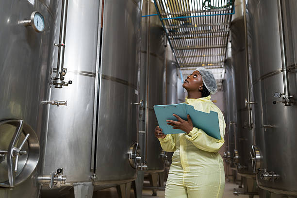 istock Wine factory, wine production, produces wine. Winemaker inspecting quality the process of fermentation during manufacturing in winery factory and stainless tank 2211700304
