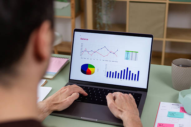 istock Businessman analyzing financial charts on laptop in home office 2211704339