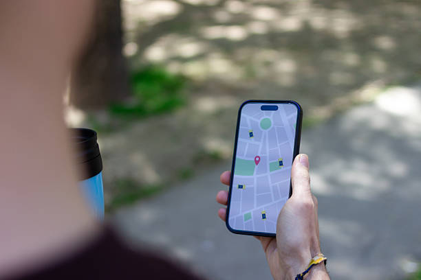 istock Man consulting a map on his phone in a park 2211705072